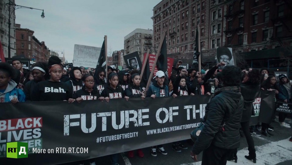 Teenagers hold a large banner reading 