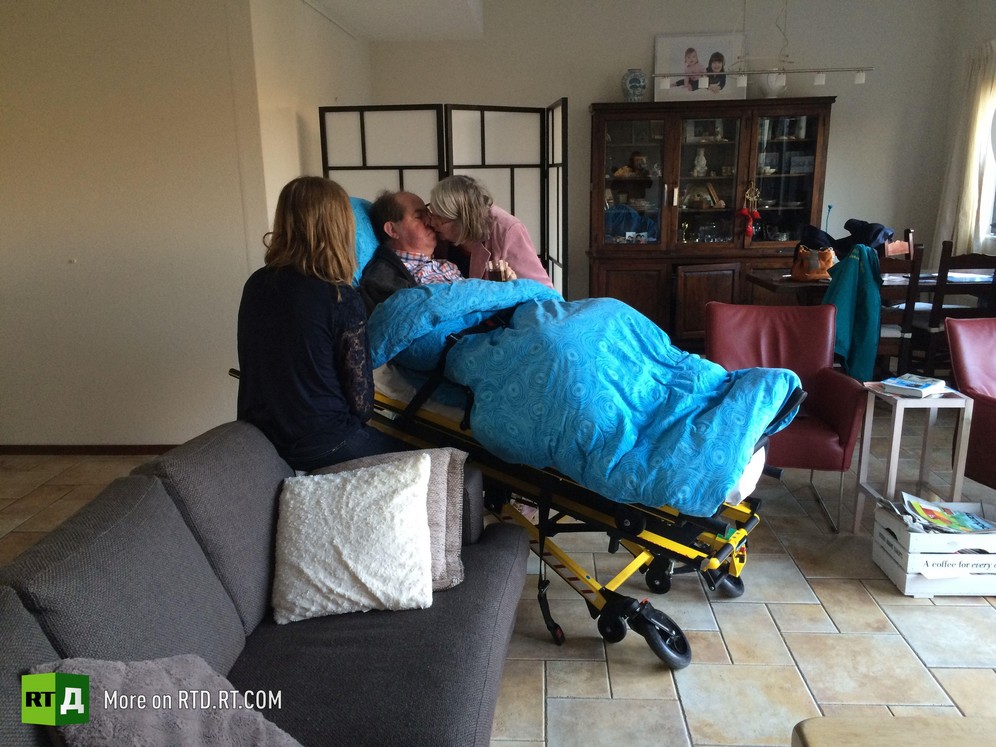 Dying patient on an ambulance stretcher, kissing his wife, with adult daughter watching, during a visit to his home made possible by the Ambulance Wish Foundation, in the Netherlands. Picture taken during filming of RTD documentary Last Wishes.