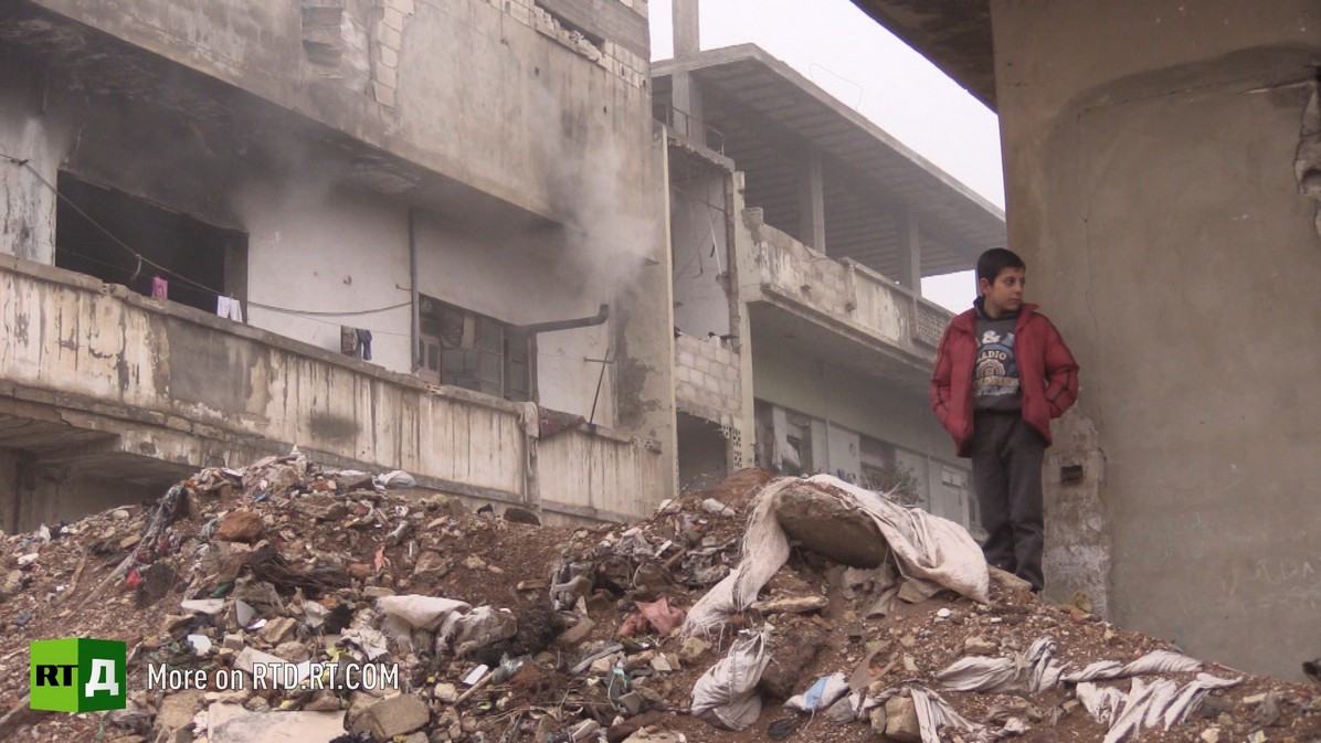 Syrian boy on the ruined streets of the city. © A still from the documentary film, Growing up with War: Children of Syria / RT