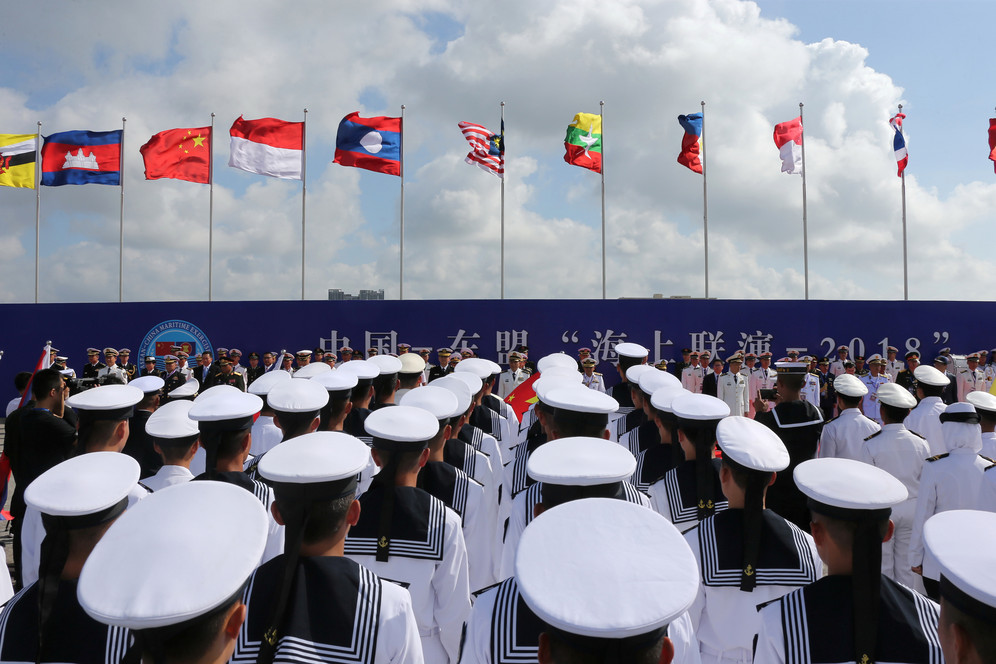 Members of the Chinese People's Liberation Army (PLA), navy and contingents from participating ASEAN countries attend the opening ceremony of the first China-ASEAN Maritime Exercise in Zhanjiang, Guangdong province, China October 22, 2018. © REUTERS Chinese soldiers and sailors with other ASEA military standing during opening ceremony of China-ASEAN Maritime exercise